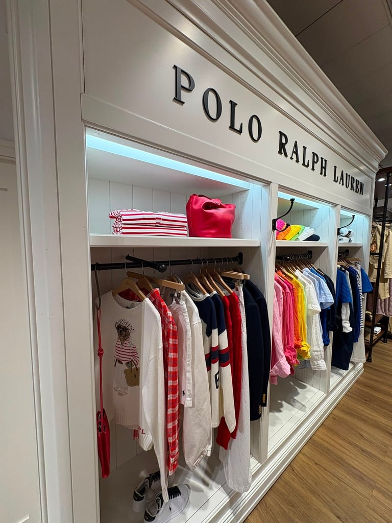 Polo Ralph Lauren storefront display with clothing on hangers and folded items on shelves